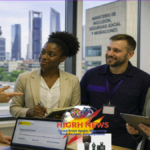 Four diverse people in Madrid, including a woman resembling Minister Elma Saiz, collaborate at an office, symbolizing labor integration.