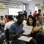 Immigrants sitting inside a Foreign National Office in Spain reviewing application documents for the regularization process.