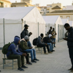 Sub-Saharan migrants wait at a reception center in Ceuta