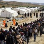 Migrants and police during the Loma Colmenar evacuation in Ceuta