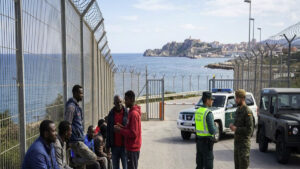 Ceuta migration crisis with migrants and Spanish security forces at the border