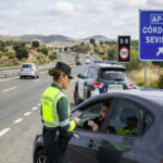 Traffic officer checking a vehicle during a roadside inspection in Spain